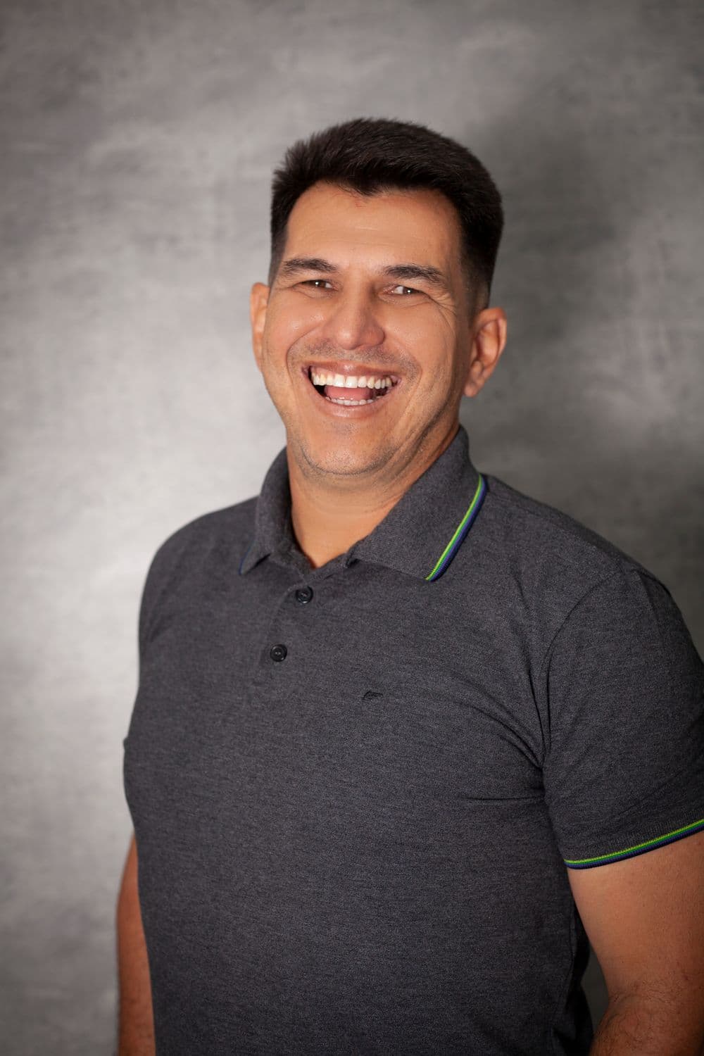 Portrait of Mateo Rivas, laughing, in a grey polo shirt